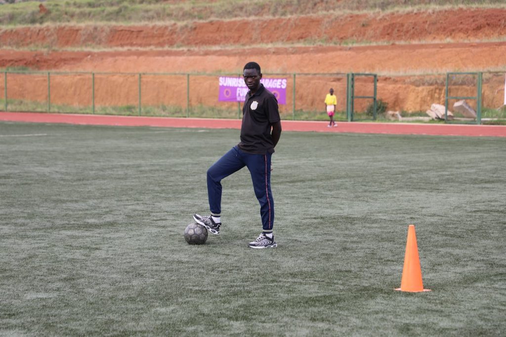 Soccer coach on field preparing for training with a focus on skill development.