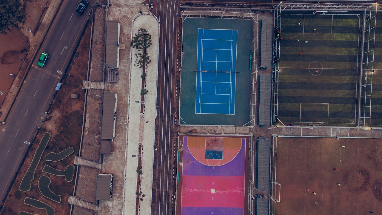 Top-down aerial shot showcasing tennis, soccer, and colorful basketball courts.